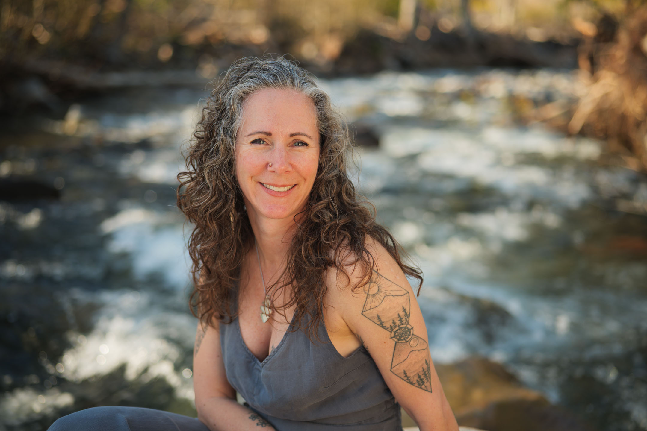 Kate Ensor smiling beside a rushing river